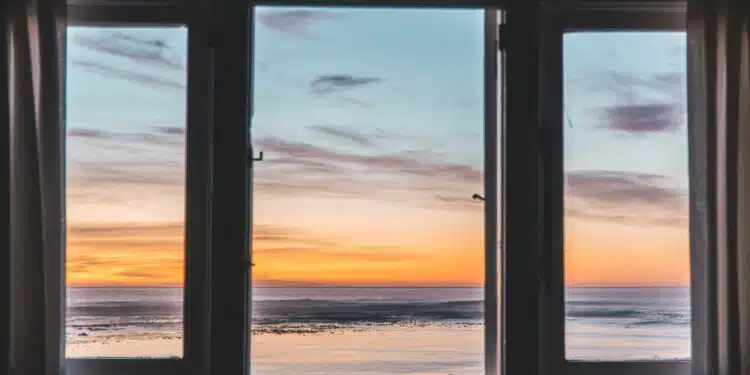white wooden framed glass window near body of water